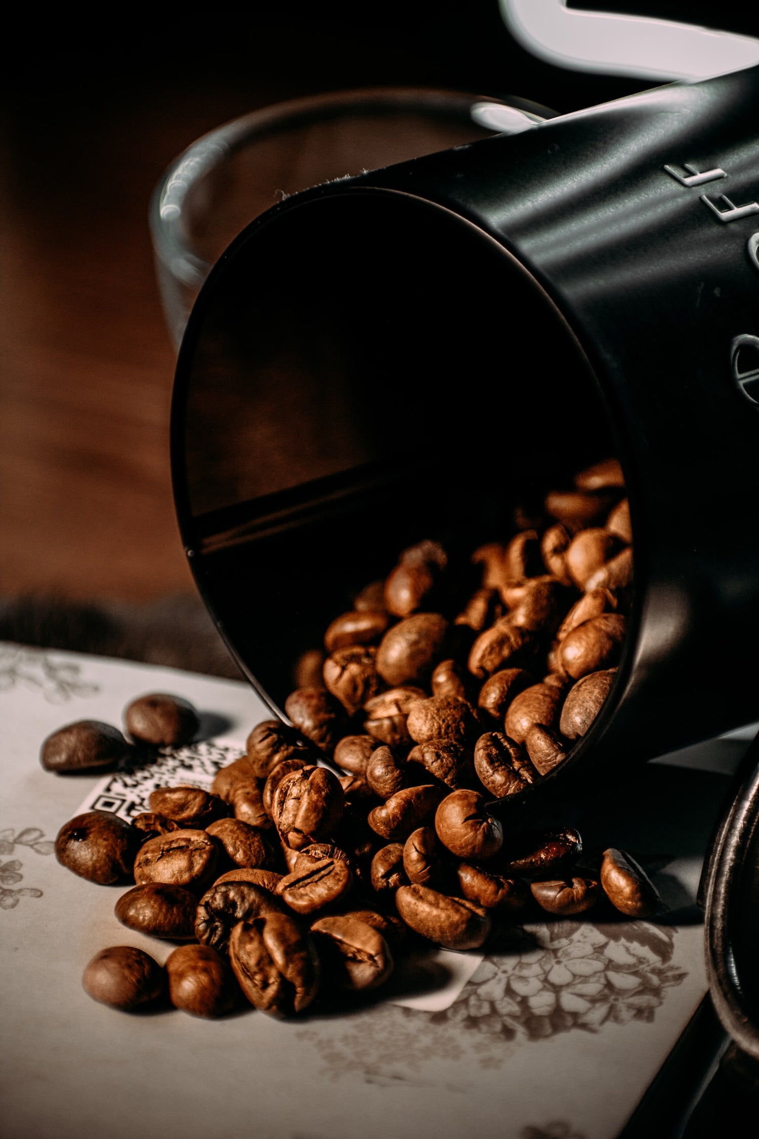 Photo de mug à café renversé de laquelle coulent des grains de café 
